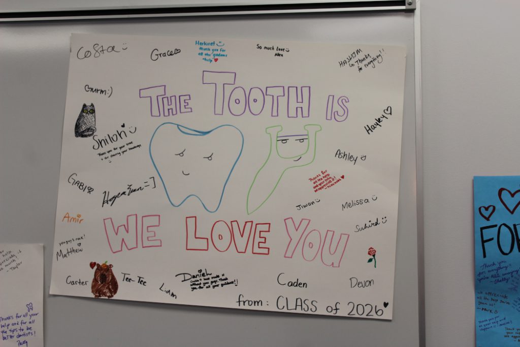 Main text reads: "The tooth is we love you. From Class of 2026." Drawings of large tooth and dental floss. The students signed name and included message. The students signed names and included messages.