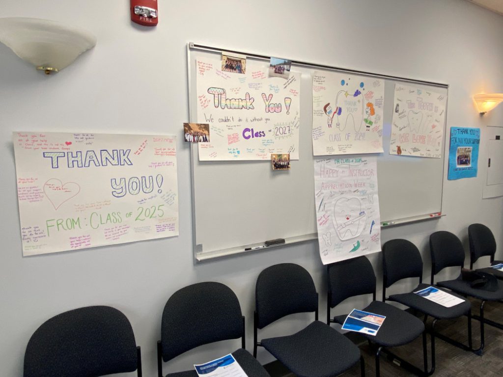 The six posters that dentistry and dental hygiene students created are posted on a wall. 