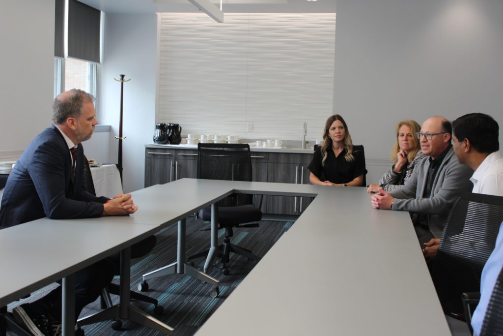 Health Minister Mark Holland speaks with a group of faculty in a board room. 