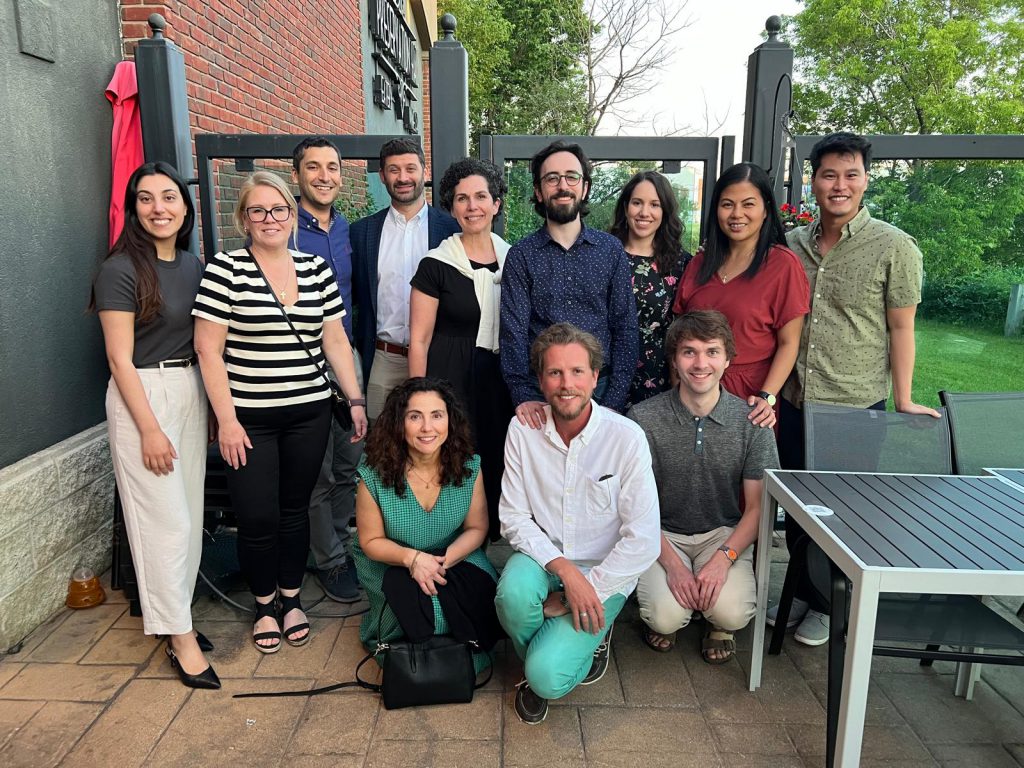 12 people pose for a photo on an outdoor patio. 