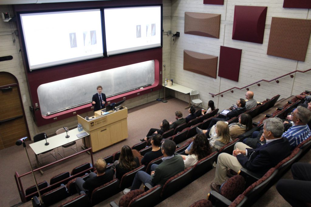 Person gives a presentation in front of an audience in a lecture theatre. 