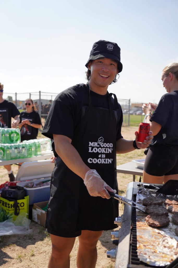 A person is grilling hamburgers on a barbecue. 