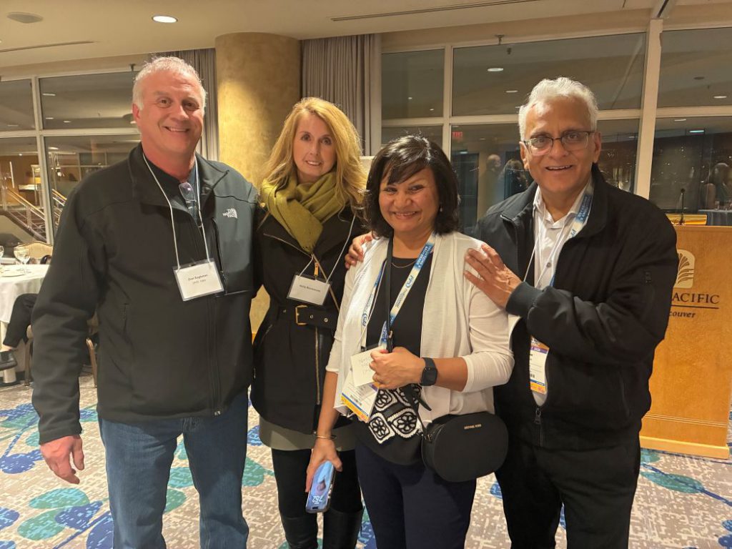 Four people pose for a photo. 