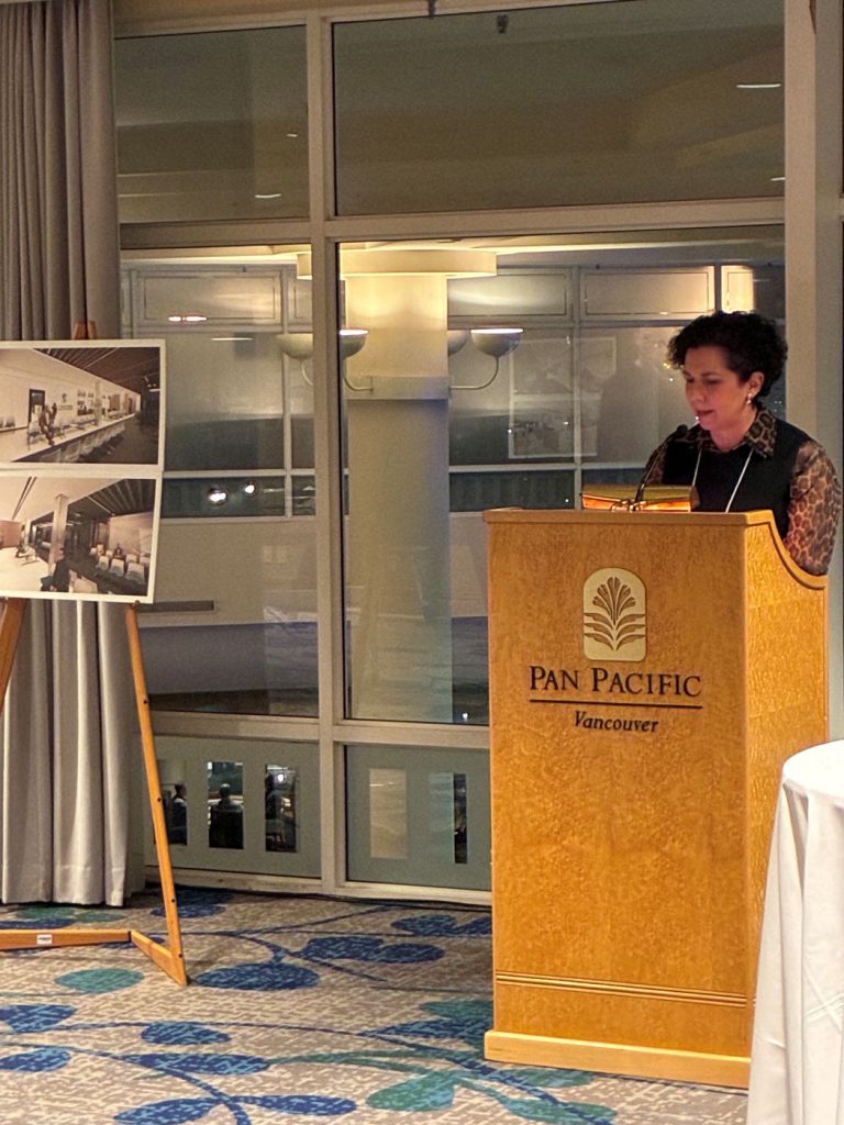 The dean speaks at a lectern. 