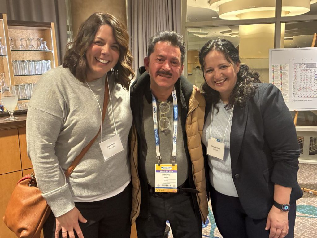 Three people pose for a photo. 