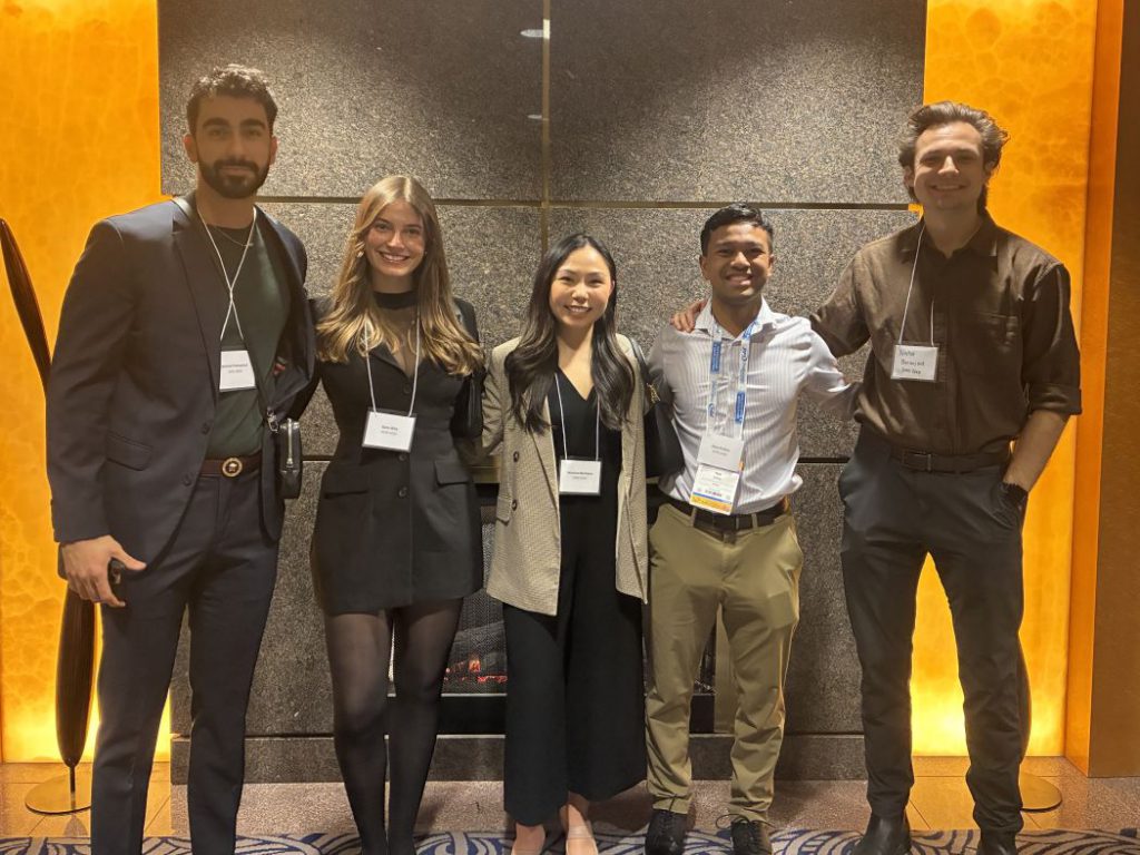 Five people pose for a photo. 