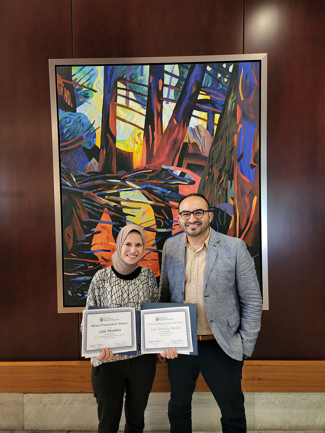 Laila Aboulatta and Dr. Sherif Eltonsy pose for a photo. Laila holds two certificates.