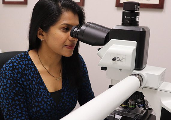 Dr. Vimi Mutalik peers intently into the large microscope on her office desk.