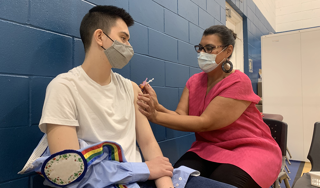 Dr. Marcia Anderson gives Ben McKenzie, 15, the first COVID-19 vaccine provided to a Manitoban under age 18 at Ma Mawi Wi Chi Itata Centre in Winnipeg.
