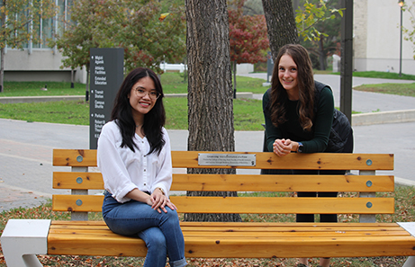 Students sitting at bench outside of nursing centre.