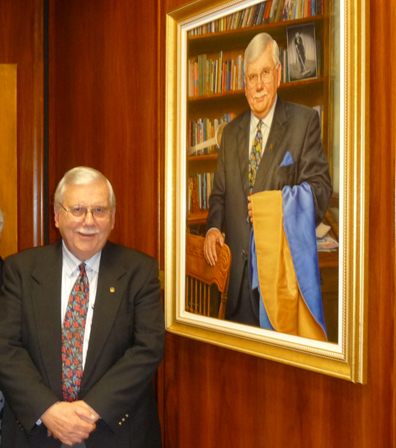 Dr. Hennen next to his portrait.