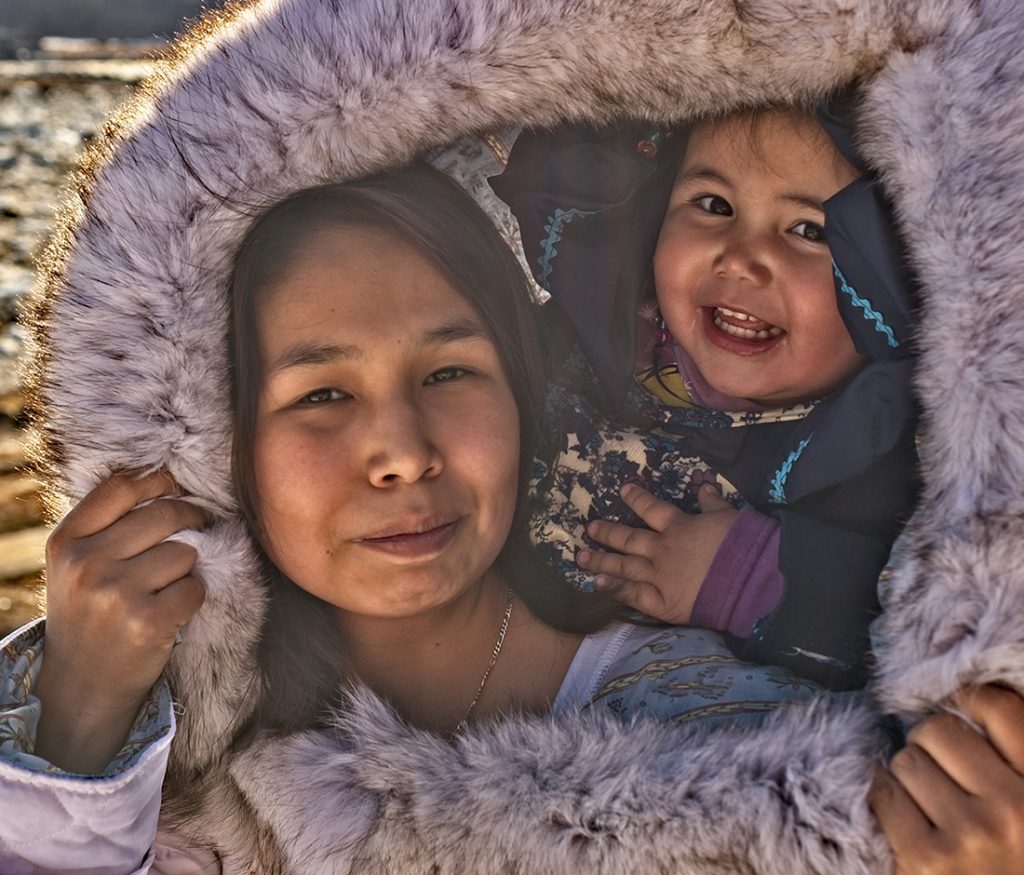 Inuit mother and daughter under a fur-lined hood. 