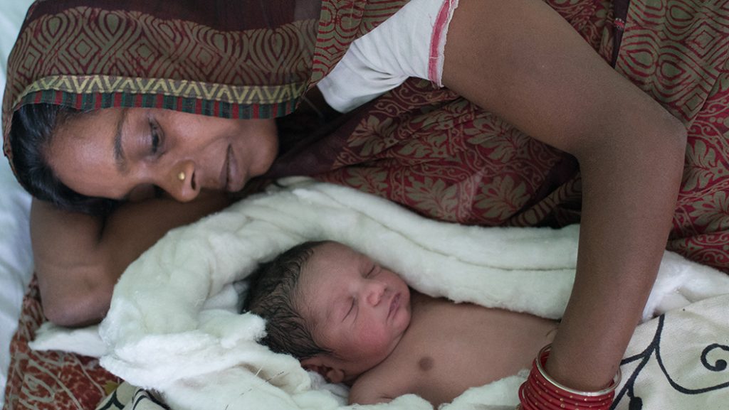 A mother in India hugs her baby.