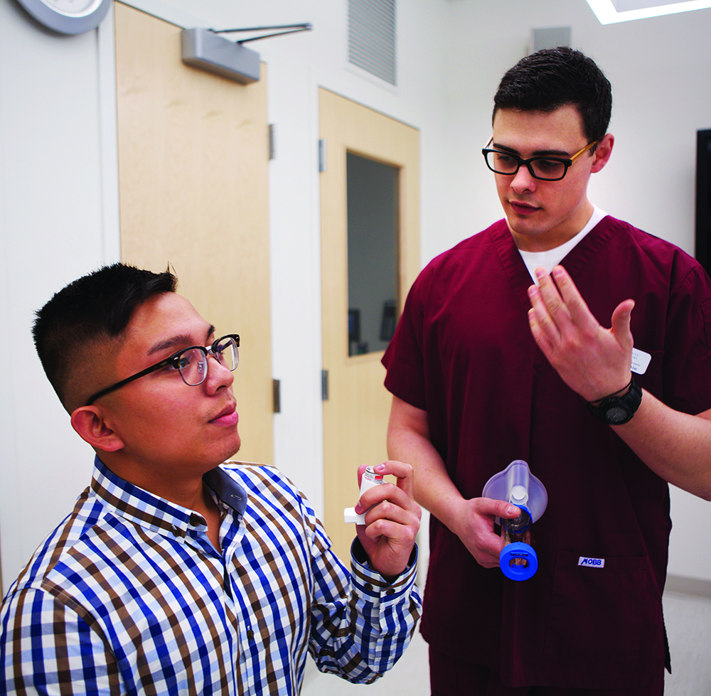 A man works on breathing techniques with a respiratory therapist.