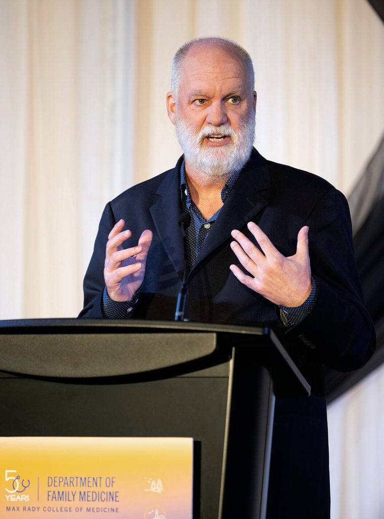 Journalist André Picard standing at a podium.