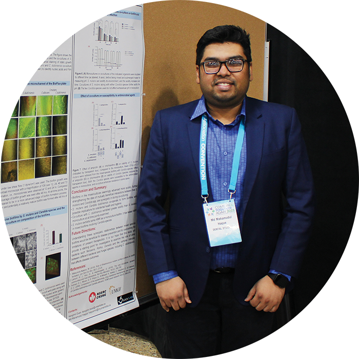 Md Mahamudul Haque stands next to his research poster.