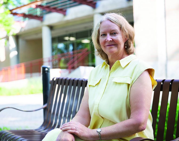 Diana McMillan sits on a bench outside the College of Nursing building.