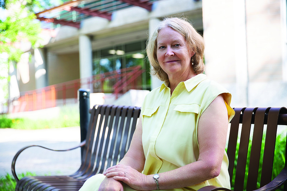 Diana McMillan sits on a bench outside the College of Nursing building.