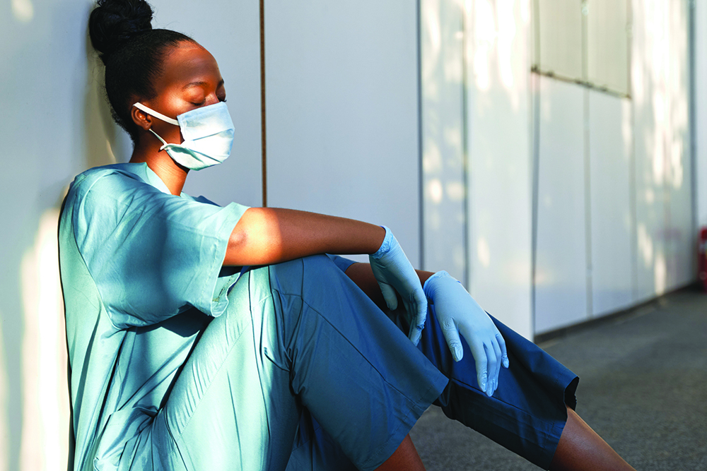 Nurse sitting on the floor, eyes closed.