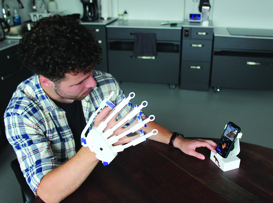 Student Silas Müller demonstrates the iManus glove.