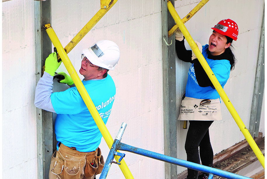 Two workers with yellow pipes.