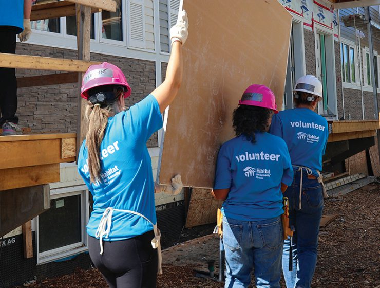 Workers carrying a board.