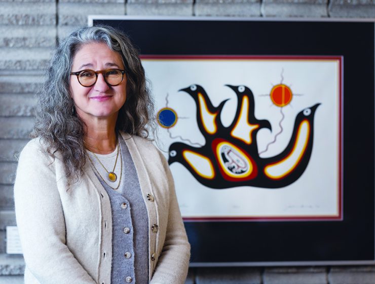 Dr. Moni Fricke with an artwork by Jackson Beardy from Garden Hill First Nation, one of the Island Lake communities where Fricke worked as a physiotherapist.