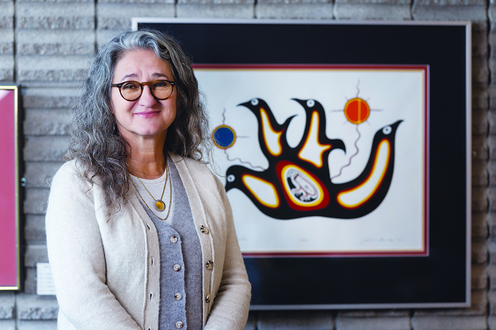 Dr. Moni Fricke with an artwork by Jackson Beardy from Garden Hill First Nation, one of the Island Lake communities where Fricke worked as a physiotherapist.