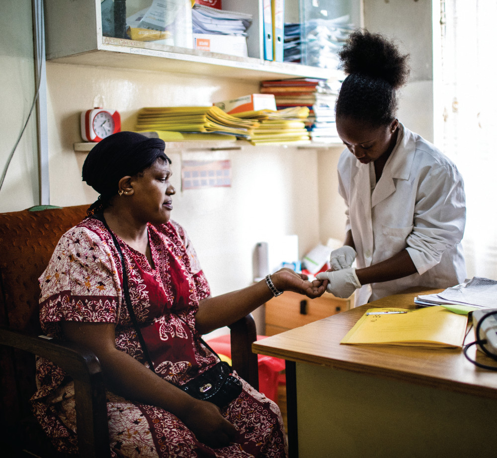 A health-care professional examines a patient's hand. 