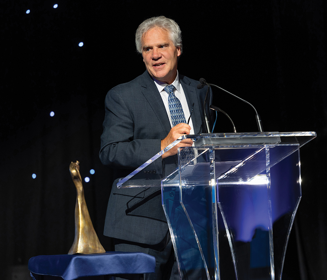 James Blanchard speaking at a podium.