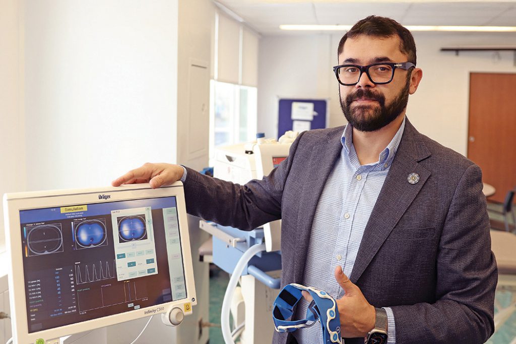 Dr. Mayson Sousa demonstrates an electrical impedance tomography machine.