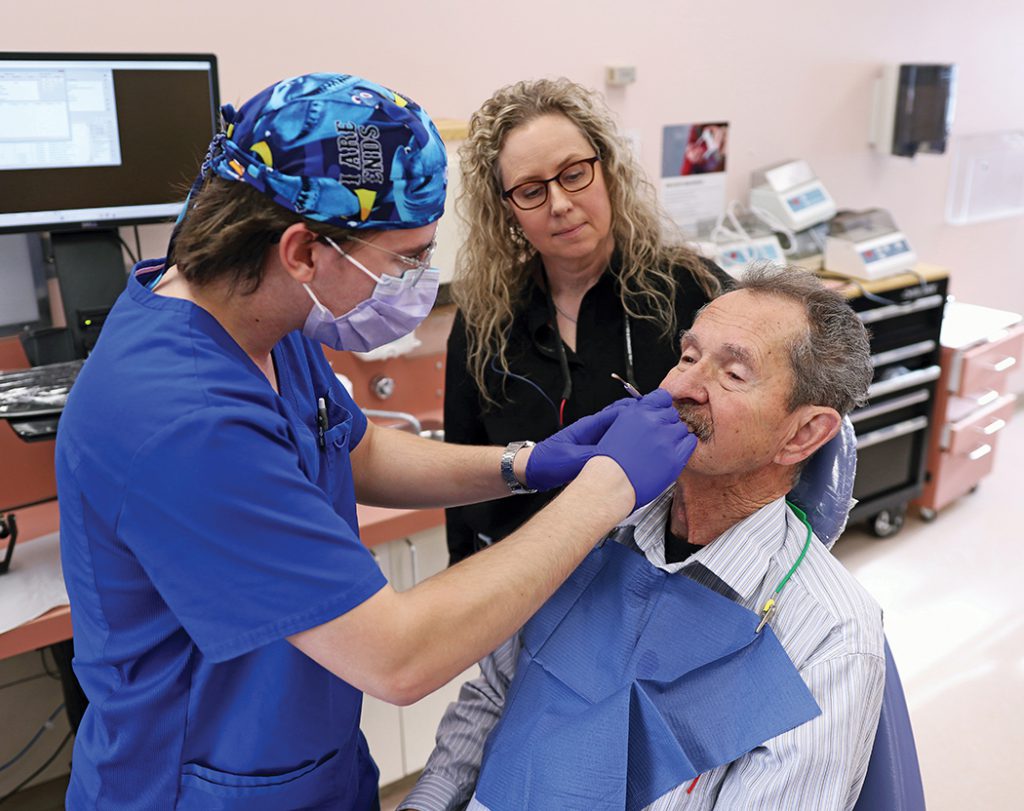 Costa Papasotiriou, a fourth-year dental student, fits Wayne, a patient who benefited from the Oral Health Access Fund, with no-cost dentures, supervised by Dr. Trenna Reeve, associate dean (clinical) at the Dr. Gerald Niznick College of Dentistry.
