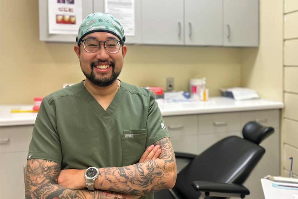 David Van wearing scrubs and smiling in a dental clinic.