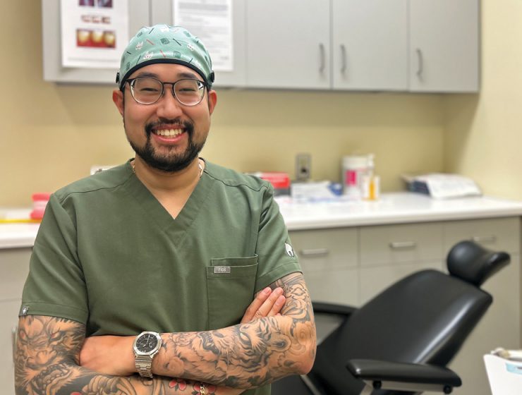 David Van wearing scrubs and smiling in a dental clinic.