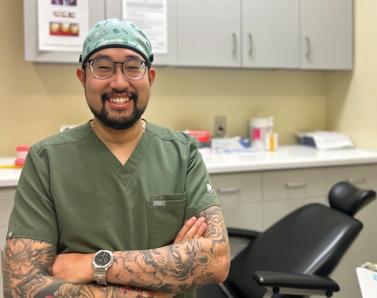 David Van wearing scrubs and smiling in a dental clinic.