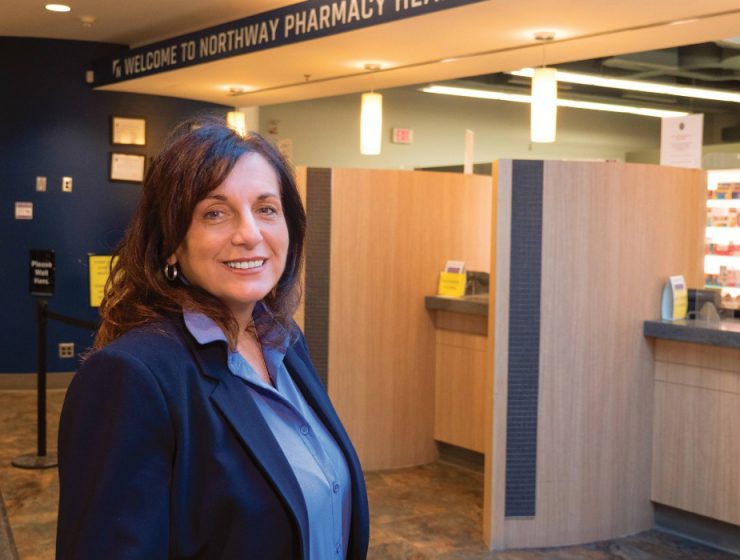 Gayle Romanetz smiles at the camera in a pharmacy.